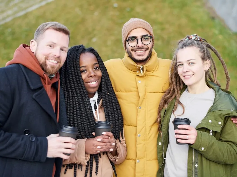 Friends at an outdoor event holding branded coffee cups